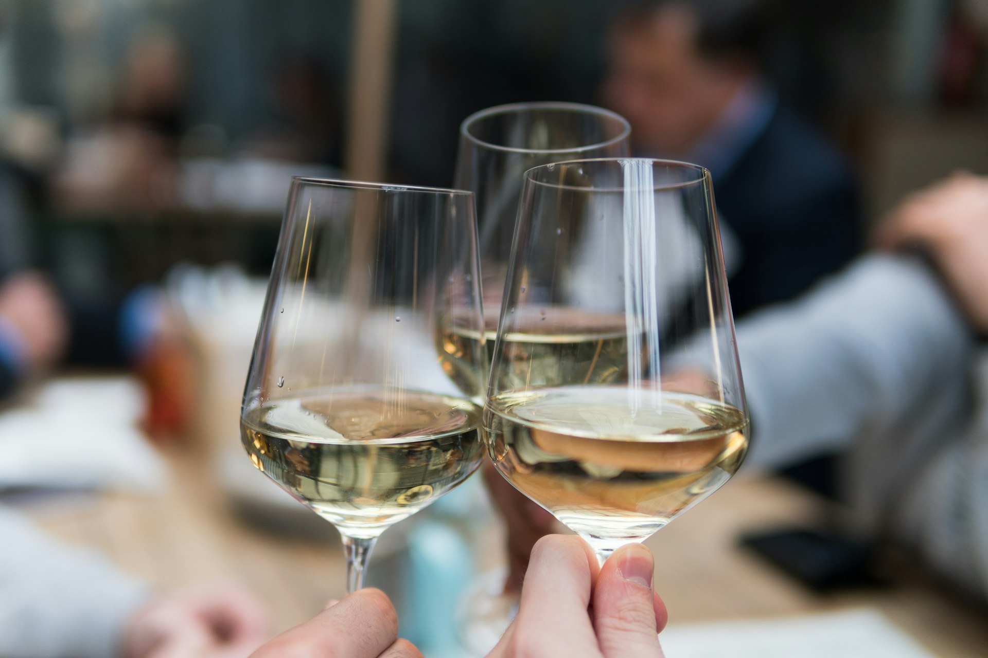 Two glasses of white wine raised in a toast