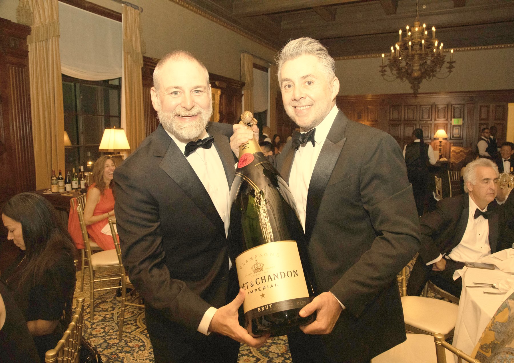 Guests in black tie with a magnum at La Paulée